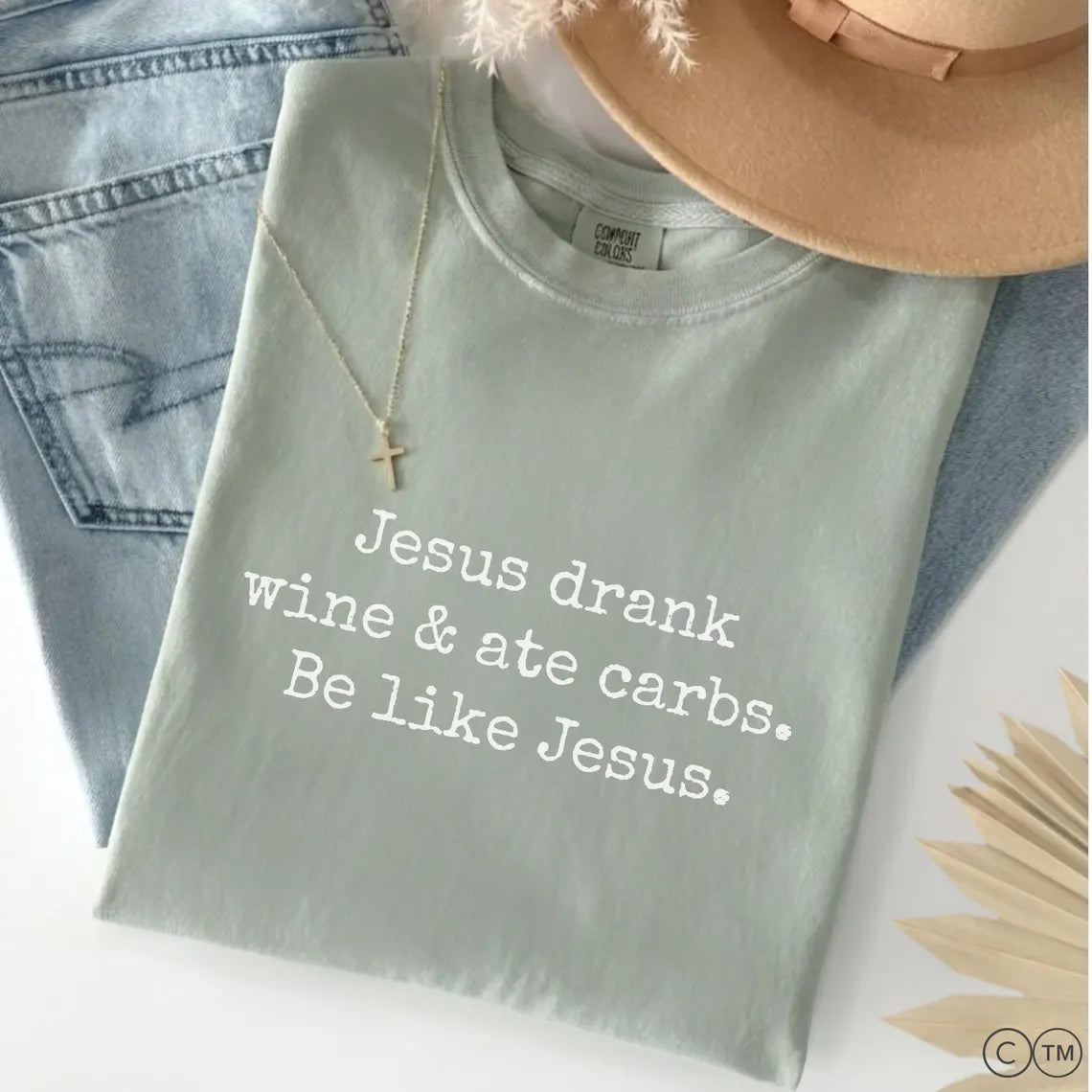 A light green t-shirt with white text that reads "Jesus drink wine & ate carbs. Be like Jesus."